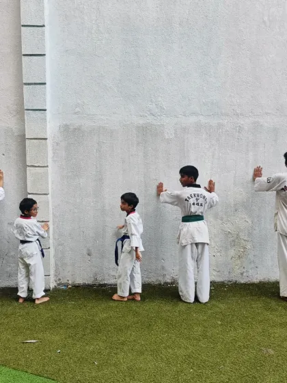 Students performing wall push-ups in a line. This kind of synchronized drill builds discipline and ensures everyone is working on their fundamental strength.