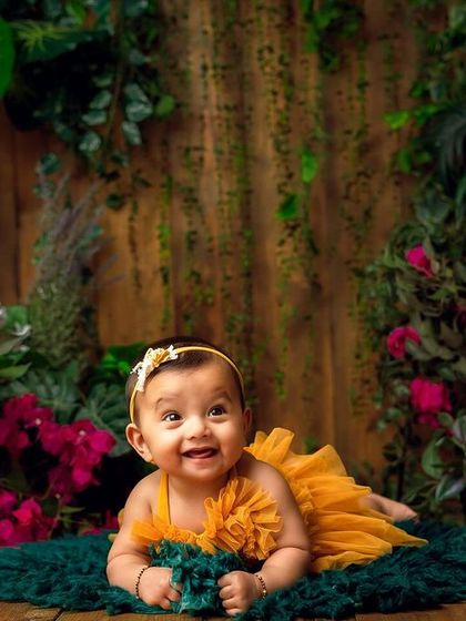 A baby in full bloom. This garden-themed sitter session uses lush greenery and vibrant flowers to create a stunning, natural portrait.