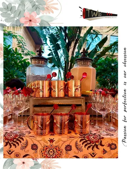 A beautifully themed bar setup featuring custom stirrers and elegant copper mugs, all tailored to the event's aesthetic.
