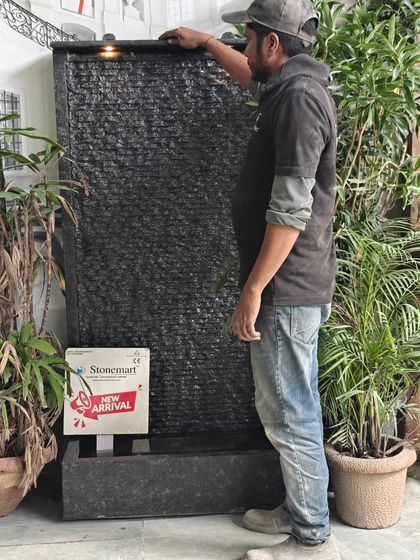 An artisan stands next to the 5-foot granite waterfall to show its height and scale. This is a substantial piece that makes a bold statement.