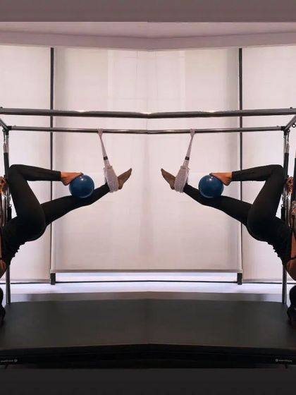 An artistic shot of an inversion on the Cadillac. This exercise decompresses the spine and challenges the core in a completely new way.