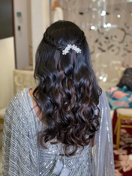 For Mishika's reception, I created this simple and elegant half-updo. A small, delicate braid is accented with a crystal clip, and the rest of the hair is styled in soft waves.