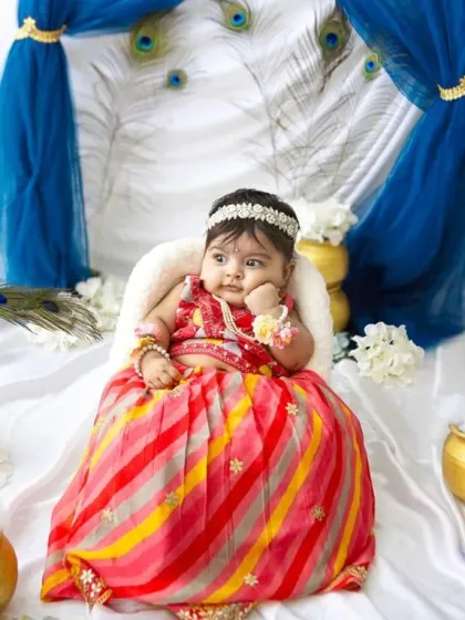 A sweet, pensive pose from our baby Radha. The lighting in the studio highlights her adorable features and the rich colours of the set.