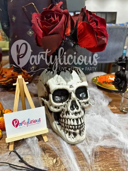 A spooky and stylish skull vase with red roses, part of our Halloween decor collection.