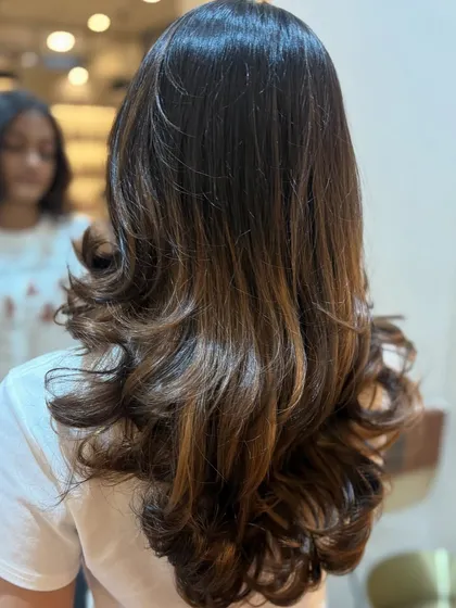 The magic of a perfect balayage is in the blend. Here you can see how the lighter pieces are woven through the hair for a stunning, dimensional effect.