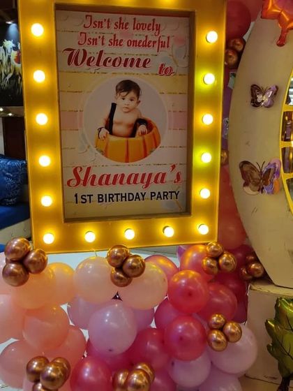 A personalized welcome sign for Shanaya's first birthday, with a cute photo and butterfly theme elements.