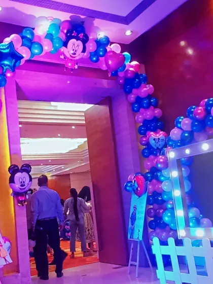 A grand balloon arch entrance for a kids' party, featuring Mickey and Minnie foil balloons. This creates an exciting welcome for young guests as they arrive.