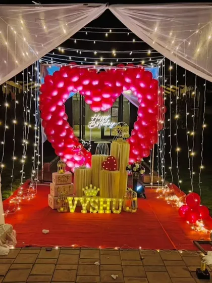 We specialize in creating unforgettable romantic surprises. This stunning outdoor cabana setup features a heart-shaped balloon arch, a red carpet entrance, and magical fairy lights, perfect for a birthday or anniversary celebration.