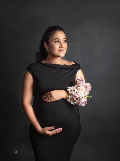 A classic and elegant solo portrait in a simple black dress against a dark backdrop, showing that casual can also be incredibly classy.