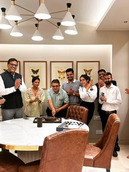 The team gathers around the conference table for a birthday cake cutting. It is these moments of shared joy that build a strong and supportive work environment.