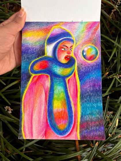 Holding the 'Seen My Aura' drawing in a garden.