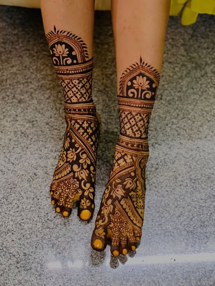 A beautiful and intricate design for the feet, featuring traditional patterns that cover the entire foot for a classic bridal look.