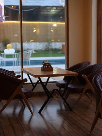A view of the pool and lawn from our indoor seating area. Even when you're inside, you can enjoy the serene, green surroundings.