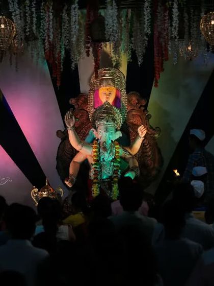 A view from the crowd looking up at the Palmbeach Cha Vighnaharta idol, capturing the perspective of a devotee.