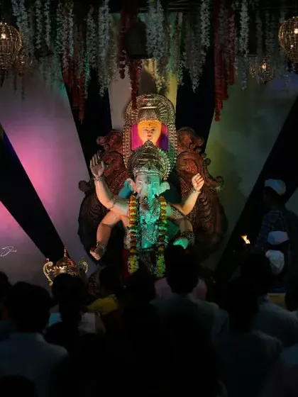 A view from the crowd looking up at the Palmbeach Cha Vighnaharta idol, capturing the perspective of a devotee.