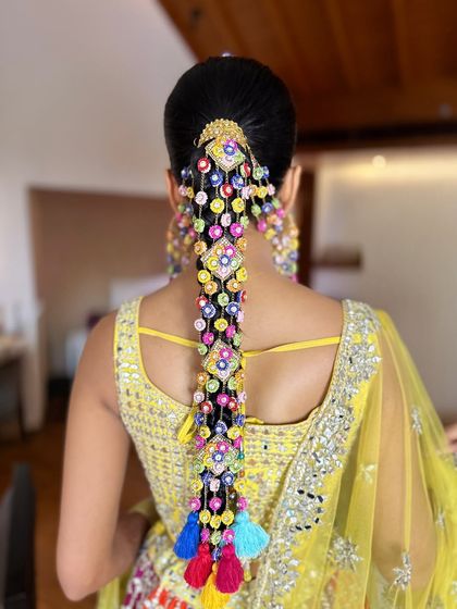 The final look from the back. The colorful accessories on the braid tie in perfectly with her mirror-work lehenga.