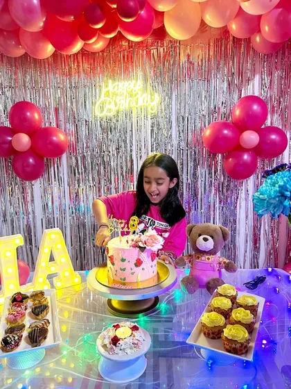 The birthday girl enjoying her pretty pink floral cake at her party. It's wonderful to see my creations as part of such happy celebrations.