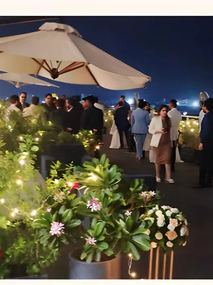 Guests mingling at a sophisticated rooftop corporate party we catered. We create a seamless and enjoyable atmosphere where your team can connect and celebrate while we manage the culinary service.