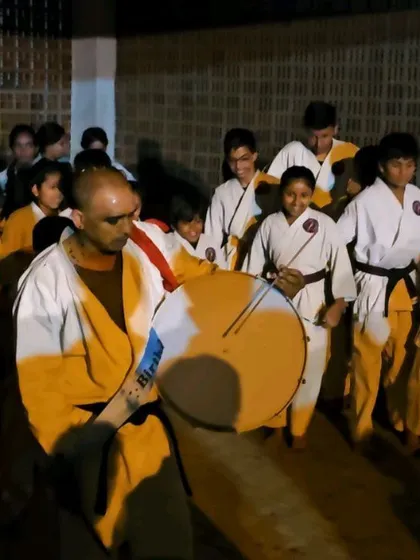 Leading the procession with a drum. Our celebrations are a vibrant part of our academy's culture.