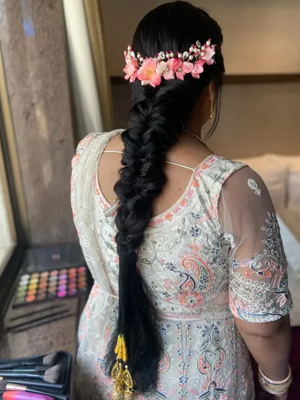 A gorgeous, thick fishtail braid adorned with a crown of pink flowers. This hairstyle is perfect for a Mehendi or Sangeet ceremony.