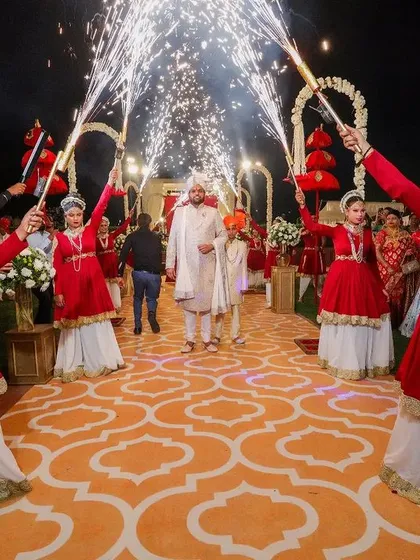 The groom's grand entrance, flanked by performers with sparklers, making for a spectacular and memorable moment.