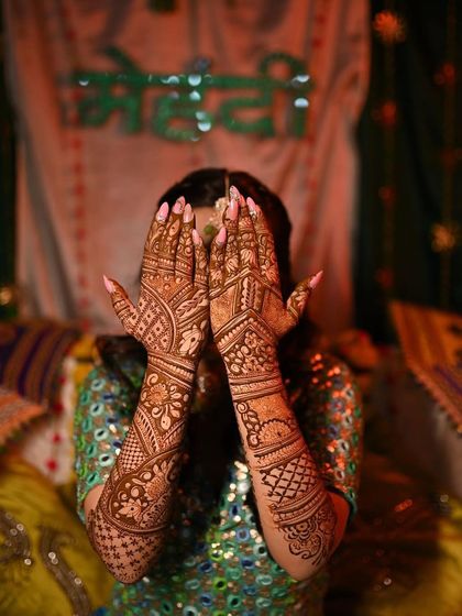 My Mehendi bride showing off her beautiful henna. The focus is on the intricate design that covers her hands and arms.