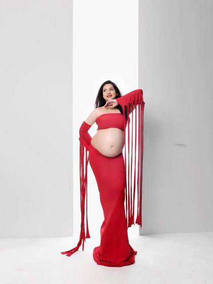 A bold, artistic take on maternity that celebrates strength and individuality. This striking red outfit against a clean white background makes a powerful statement.