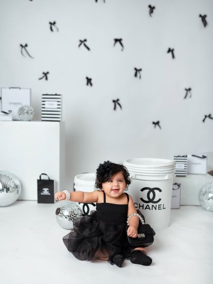 A big, joyful smile from the baby of the family, showing that even high-fashion shoots can be full of fun and giggles.