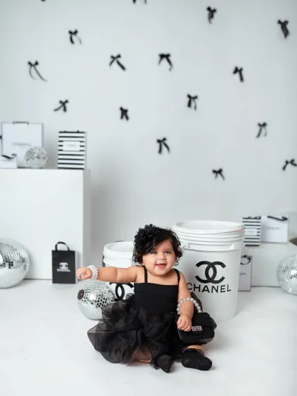 A big, joyful smile from the baby of the family, showing that even high-fashion shoots can be full of fun and giggles.