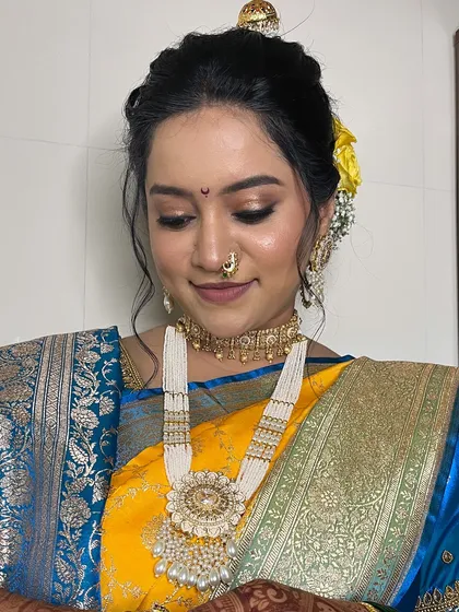 A close-up of the eye makeup, featuring a soft gold shimmer and winged liner.