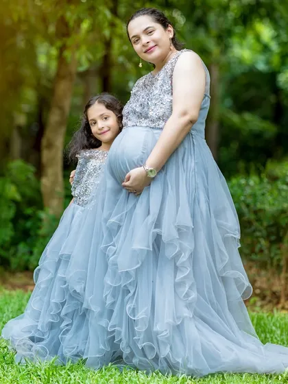 Celebrating with the whole family is so special. I offer matching mother and daughter gowns, like this beautiful grey ruffled set, to create truly memorable portraits that show the bond between a mother, her daughter, and the new baby on the way.