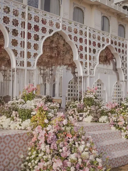 A detailed view of the stage steps, adorned with cascading pastel floral arrangements. The custom-printed tiles on the steps add another layer of bespoke detail to the design.