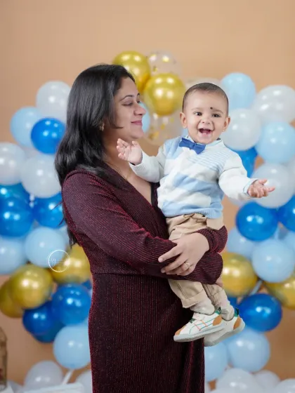 A joyful mother and son portrait. The baby's huge smile says it all. These are the happy, energetic moments that truly define a first birthday celebration.
