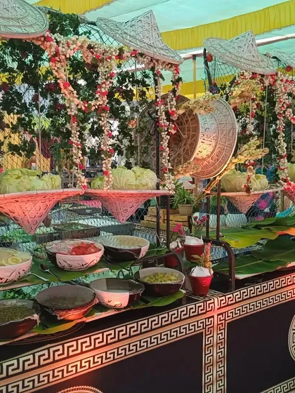 This Asian-themed salad station features decorative elements like bamboo fans and banana leaves, creating a unique and immersive experience for guests.