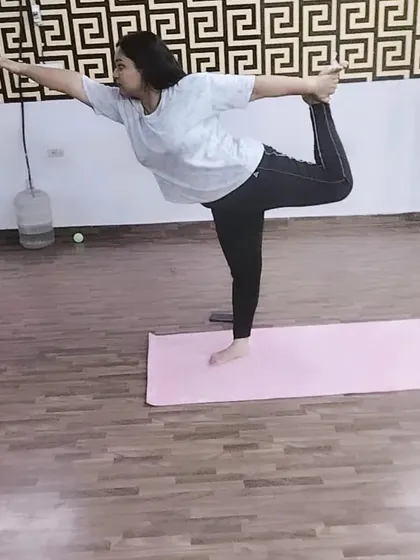 A graceful execution of Natarajasana, the dancer's pose. This posture challenges your balance while providing a deep stretch for the shoulders and chest.