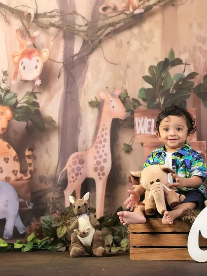 A "Wild One" first birthday shoot with a jungle theme, featuring the birthday boy surrounded by cute animal props.