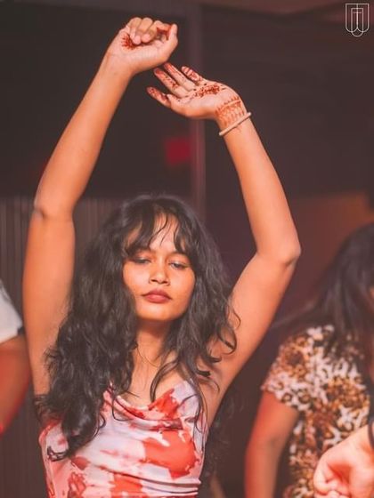 A guest dancing with her hands in the air at TYD.