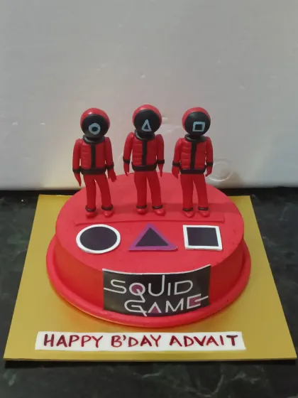 A cake for fans of the thrilling series "Squid Game." This striking red cake features the iconic shapes and masked guard figurines made from fondant.