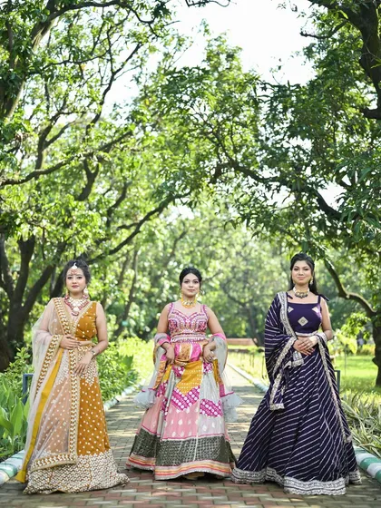 Three of our colorful festive lehengas lined up. This image showcases the mustard yellow, pink patchwork, and purple leheriya designs together.