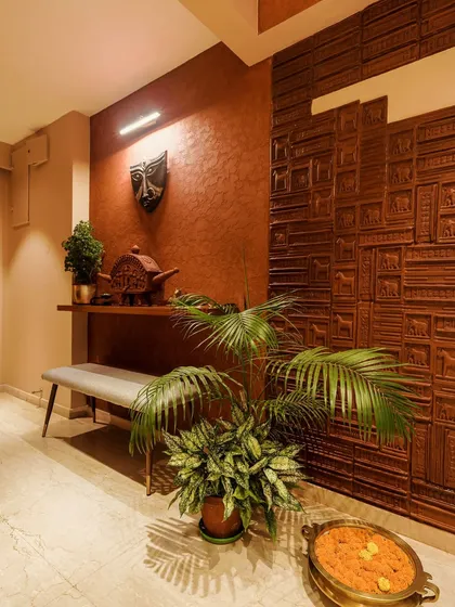 A hallway featuring a textured wall with intricate wooden carvings of elephants and other traditional motifs.