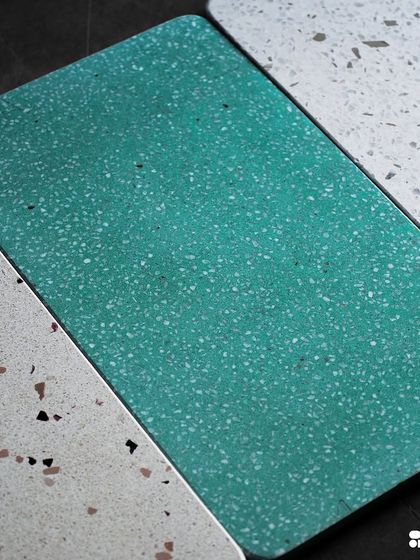 A selection of new terrazzo designs, featuring a vibrant teal, a classic white with black and brown flecks, and a subtle off-white with fine aggregate.