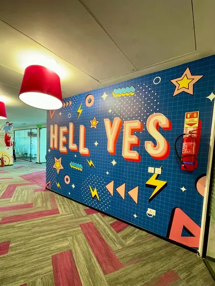 A fun, pop-art style mural with the words "Hell Yes!" designed to bring a burst of energy and motivation to the Clovia office hallway.
