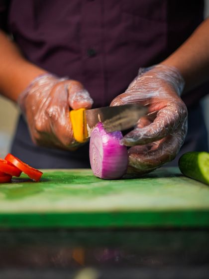 It all starts with fresh ingredients. This image shows our chef carefully slicing a red onion, a small but important step in creating our delicious meals.