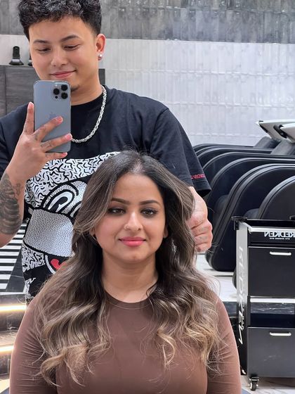 This client's new look was created using Redken 09P and 09V to achieve a cool, ashy tone that beautifully complements her skin. The soft waves and face-framing highlights complete the transformation.