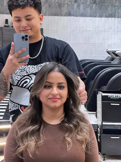 This client's new look was created using Redken 09P and 09V to achieve a cool, ashy tone that beautifully complements her skin. The soft waves and face-framing highlights complete the transformation.