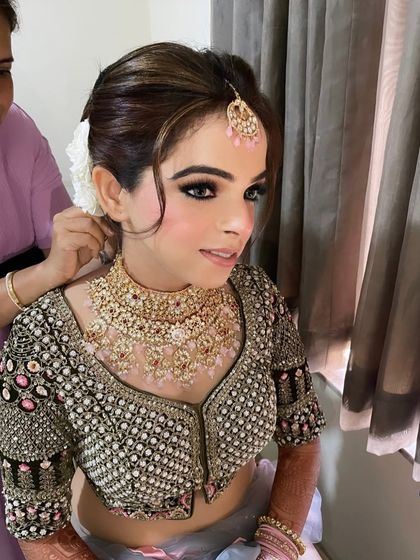 How gorgeous is Roshni. We created a beautiful look for her with smokey eyes and a flawless base, complemented by a classic bun adorned with fresh flowers.