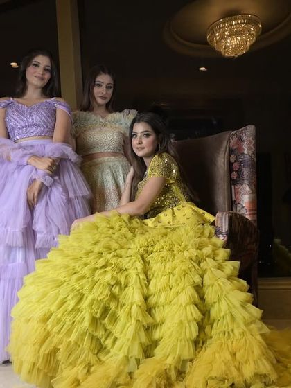 A client seated in the stunning lime-yellow ruffle gown. The dress features a long train made of countless layers of tulle ruffles and a mirror-embellished bodice.