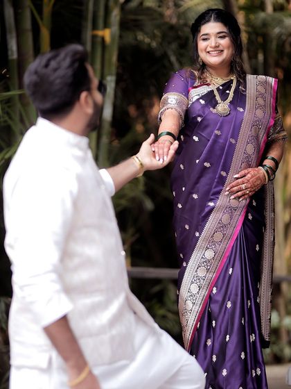 A classic and romantic pose where the groom holds his bride's hand. This image highlights the traditional Maharashtrian attire and the gentle connection between the couple.