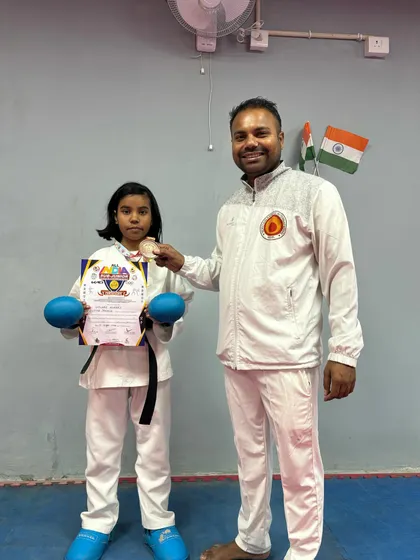 Shivani with her coach, Pankaj, proudly showing her bronze medal from the national championship.