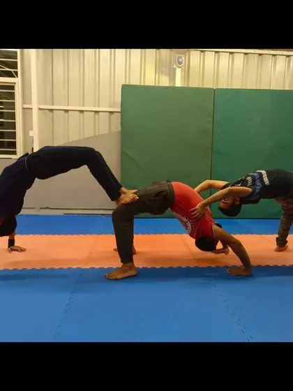 This creative, multi-person bridge pose shows how we use teamwork to build flexibility and strength. It's a fun challenge that requires everyone to work together.